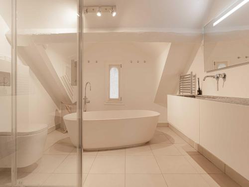 une salle de bain blanche avec une baignoire et un lavabo dans l'établissement Spacious house - AC- 5BR-12P- Deauville, à Deauville
