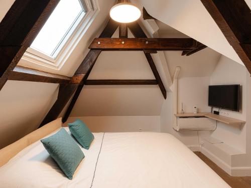 - une chambre mansardée avec un lit et une télévision dans l'établissement Spacious house - AC- 5BR-12P- Deauville, à Deauville