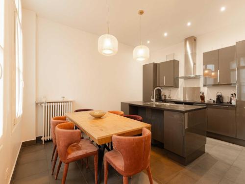 une cuisine avec une table en bois et des chaises oranges dans l'établissement Spacious house - AC- 5BR-12P- Deauville, à Deauville