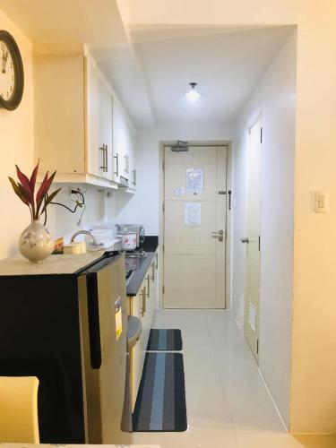 a kitchen with a hallway leading to a door at CHIC ROOM pasay sea residence in Manila