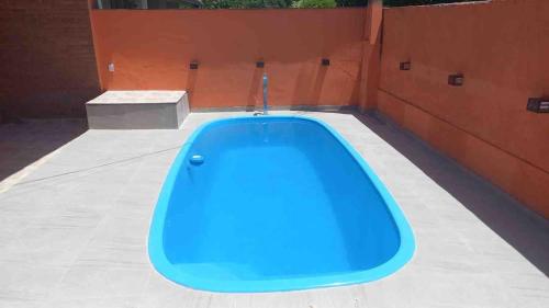 a blue tub sitting on the side of a building at Casa com Piscina Balneário Oásis - Quadriciclo in Peruíbe