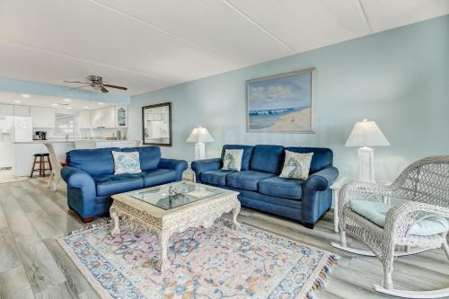 a living room with blue couches and a coffee table at Striking Oceanview Condo in Fernandina Beach