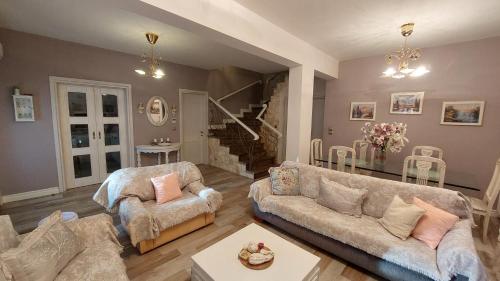 a living room with two couches and a staircase at Lux Center Apartment in Litochoro