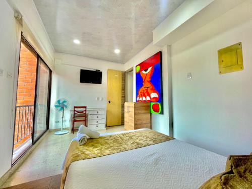 a bedroom with a bed and a painting on the wall at Hotel Torre Primavera in Medellín