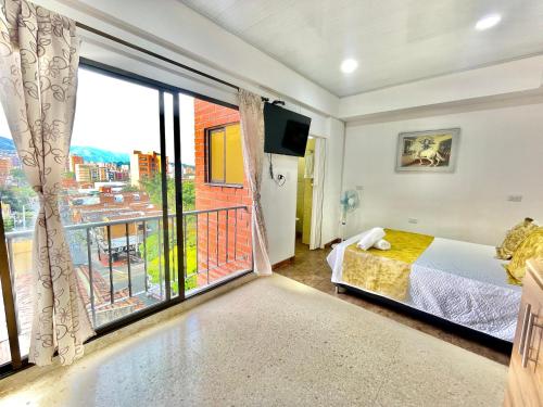 a bedroom with a bed and a large window at Hotel Torre Primavera in Medellín