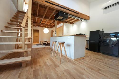 a kitchen with a staircase and stools in a room at Rikka Soyuji Hinoki Woodbath 2 bedrooms Kitchen Free parking in Takayama