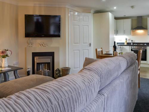 a living room with a couch and a tv on the wall at Alderson Mews in Brigham