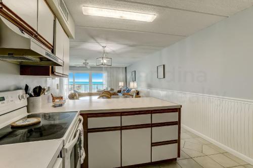 a kitchen with white cabinets and a counter top at Oceanfront Condo w Balcony in Amelia Island