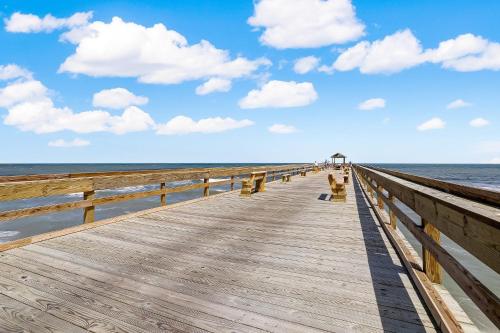 a wooden pier stretches out into the ocean at Oceanfront Condo w Balcony in Amelia Island