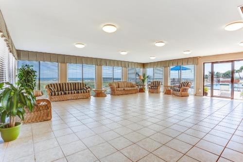 a large room with chairs and tables and windows at Oceanfront Condo w Balcony in Amelia Island
