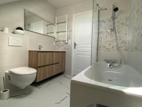 une salle de bain blanche avec des toilettes et un lavabo dans l'établissement Charmant duplex rénové au cœur de Lajarrige avec wifi - FR-1-306-1297, à La Baule