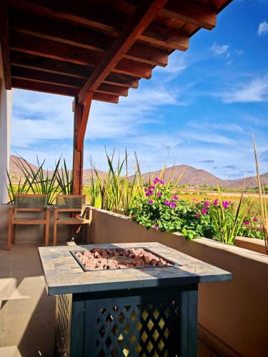 a patio with a grill with a view of a field at Hotel Flores de Sal-Valle de Guadalupe in Valle de Guadalupe