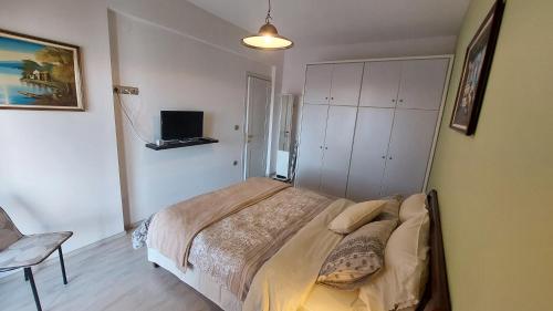 a bedroom with a bed and a tv on a wall at Lux Center Apartment in Litochoro