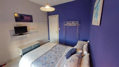 a bedroom with a bed and a purple wall at Lux Center Apartment in Litochoro