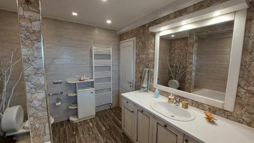 a bathroom with a sink and a mirror at Lux Center Apartment in Litochoro