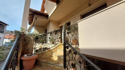 a balcony with a wrought iron railing and stairs at Lux Center Apartment in Litochoro