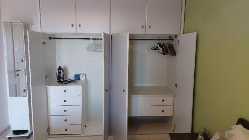 a closet with white cabinets and a dresser at Lux Center Apartment in Litochoro