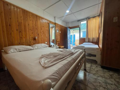 - une chambre avec 2 lits dans une pièce dotée de murs en bois dans l'établissement Hostal Luna Llena Getsemaní, à Carthagène des Indes