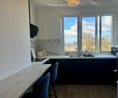 une cuisine avec une table et des chaises et une fenêtre dans l'établissement Cozy 2 bedrooms, à Dunkerque