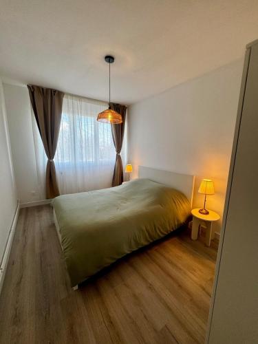 une chambre avec un lit vert et une fenêtre dans l'établissement Cozy 2 bedrooms, à Dunkerque