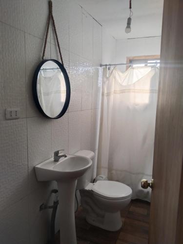 Un baño con inodoro, lavabo y espejo. en Cabaña con jacuzzi Olmué, en Olmué