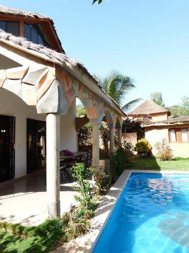 a house with a swimming pool in front of a house at Villa Dallie in Saly Portudal