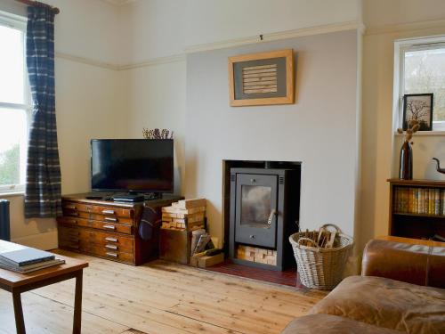 a living room with a fireplace and a television at Kingswood in Whitehaven
