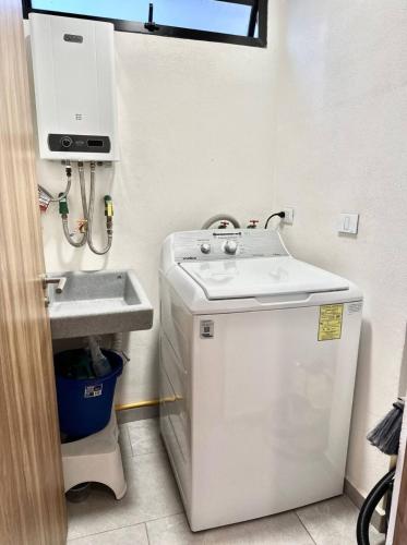 a small bathroom with a sink and a washing machine at Moderno Loft Totalmente Equipado in Lomas de Angelopolis