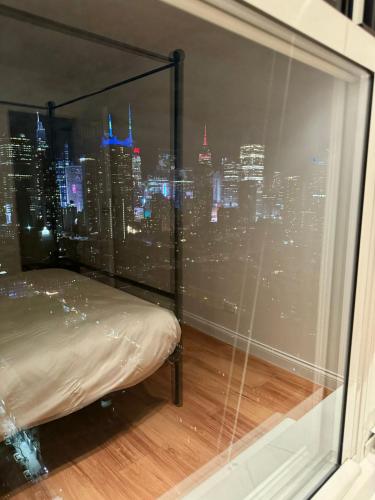 a bedroom with a view of a city from a window at Midtown High Floor Fantastic Panoramic City View Corner 2 Bedroom Apartment in New York