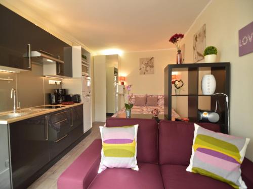 Il comprend un salon avec un canapé violet et une cuisine. dans l'établissement Apartment in Bayeux near Beaches & Tapestry, à Bayeux