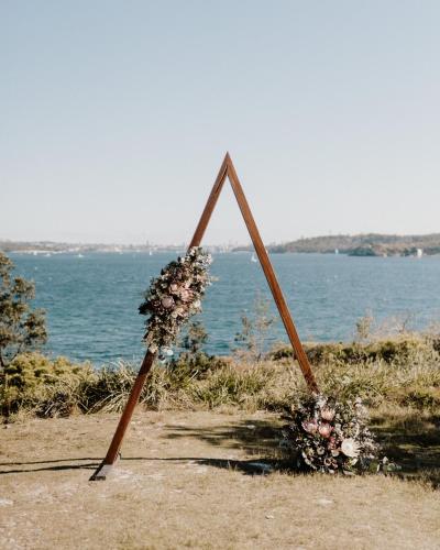 a wooden frame with a bunch of flowers on the beach at Q Station in Sydney