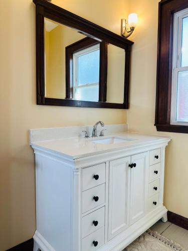 a bathroom with a white sink and a mirror at Cozy Allentown Home in Buffalo