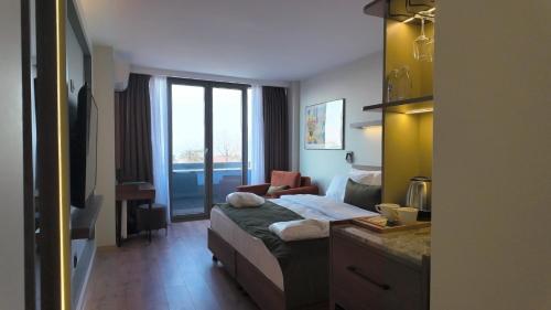 a hotel room with a bed with a desk and a window at Yıldız Termal Otel in Çekirge İstasyonu