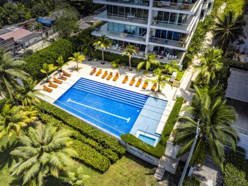 an overhead view of a swimming pool with palm trees and a building at Paraíso Costero Morros Vitri La Boquilla familiar 4 personas in Cartagena de Indias