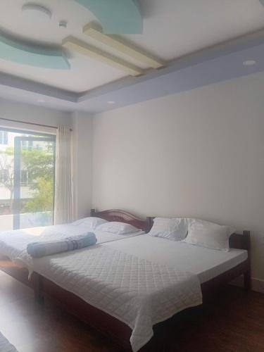 a large bed in a bedroom with a window at MOTEL Đồng Khởi in Giồng Tú Ðiền
