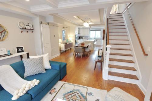 a living room with a blue couch and a staircase at Stroll to The Hip Strip From Shaw Basement Suite in Washington, D.C.