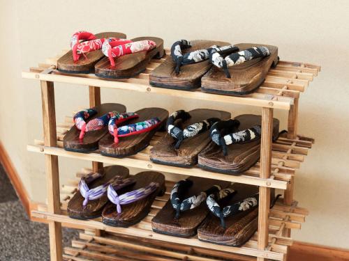 a display of shoes on a wooden shelf at Ichinomata Onsen Grand Hotel in Shimonoseki