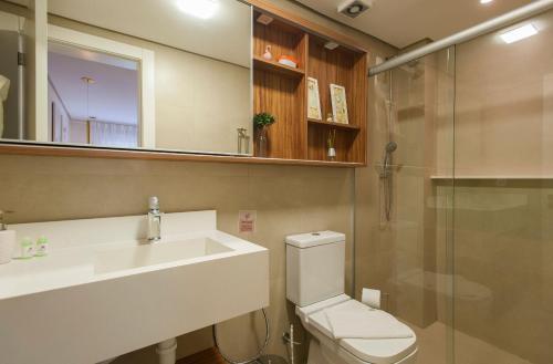 a bathroom with a toilet and a sink and a shower at Locar - in Canela Villaggio Caracol Novissimo in Canela