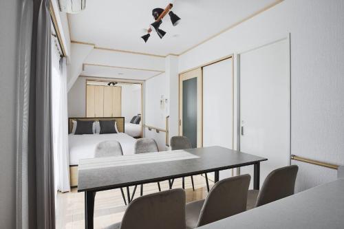 a room with a table and chairs and a bed at Arcadia Nishikamata in Tokyo