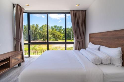 a bedroom with a large bed with a large window at 5bdr pool villa in Laguna Park 2 in Phuket