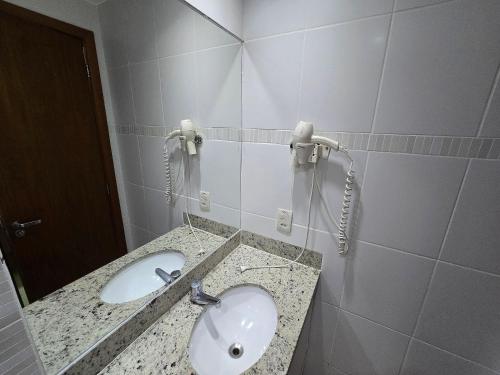 a bathroom with a sink and a phone at Apartamentos em Rio Quente com maravilhosa área de lazer e excelente localização in Rio Quente