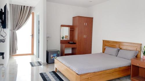 a bedroom with a bed and a large window at Hotel & Homestay Long Vũ Măng Đen in Kon Tum