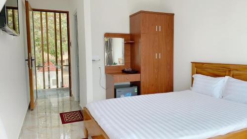 a bedroom with a bed and a large window at Hotel & Homestay Long Vũ Măng Đen in Kon Tum