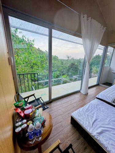 a bedroom with a bed and a table with food on it at Hotel & Homestay Long Vũ Măng Đen in Kon Tum