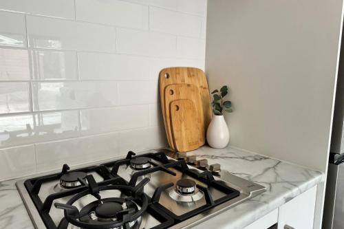 a kitchen stove top with a wooden cutting board at The Cabins at Douglas Scrub in Blewitts Springs