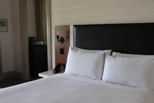 a bed with white pillows in a hotel room at Q Station in Sydney