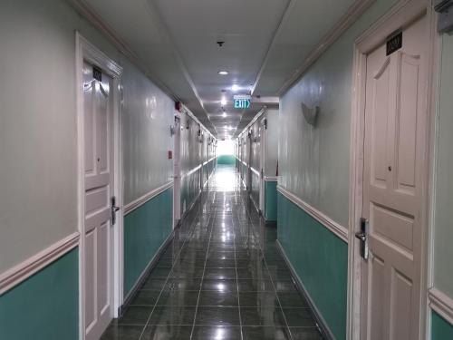 a corridor of a hallway with green and white walls at Metro Park Hotel - Cebu City in Cebu City