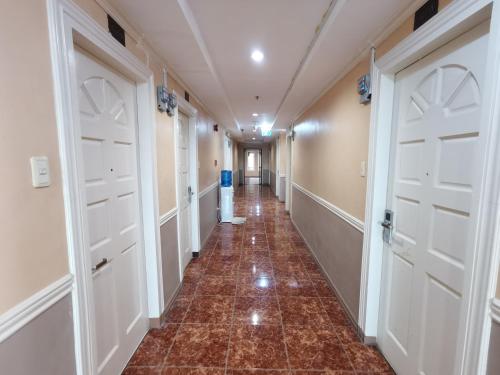 a hallway with white doors and a tile floor at Metro Park Hotel - Cebu City in Cebu City