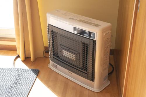 a microwave oven sitting on top of a computer tower at +C FURANO in Furano