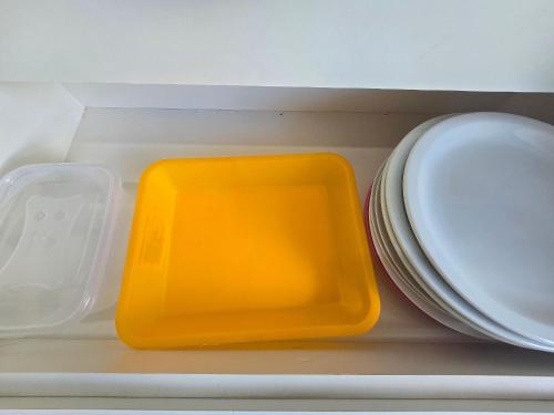 a yellow tray sitting in a drawer next to a plate at Apartamentos em Rio Quente com maravilhosa área de lazer e excelente localização in Rio Quente